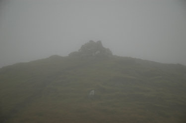 Picture of a cairn and trigpoint in the clouds