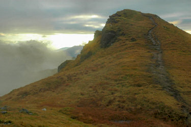 Picture of a hill top surrounded by clouds